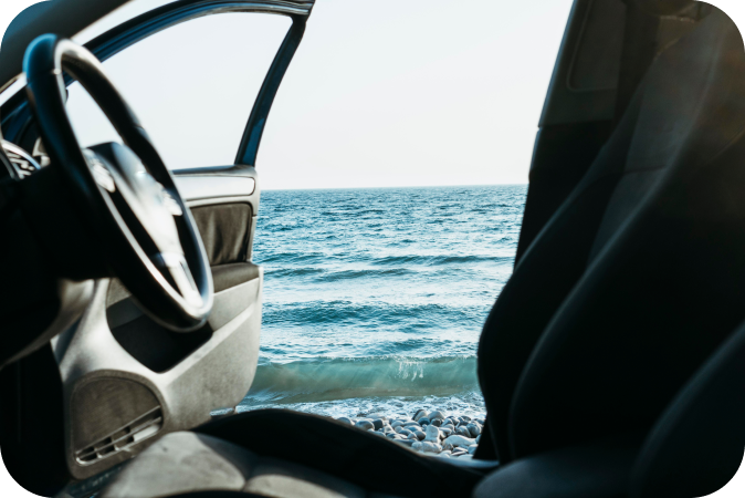 Carro com porta aberta junto ao mar